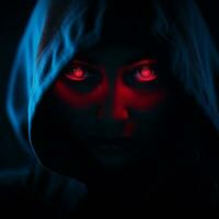 un mujer en un capucha con brillante rojo ojos generativo ai foto