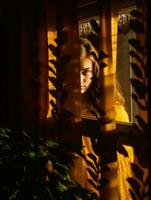 a woman in a yellow dress looking out the window generative ai photo