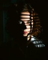 un mujer en el oscuro con persianas en su ojos generativo ai foto