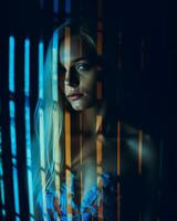 a woman with long blonde hair standing in front of bars generative ai photo