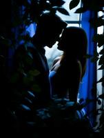 silhouette of a man and woman kissing in front of a window generative ai photo