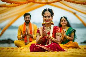 a bride and groom sitting on the beach in traditional indian attire. AI-Generated photo