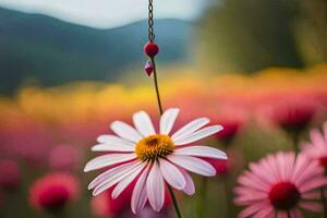 a pink flower is hanging from a chain in a field. AI-Generated photo