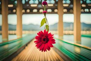 a red flower hanging from a bridge over a lake. AI-Generated photo