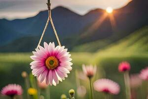 a pink flower hanging from a rope in front of a mountain. AI-Generated photo