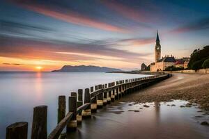 el puesta de sol terminado el mar y un Iglesia torre. generado por ai foto