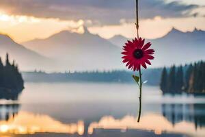 a red flower hanging from a vine over a lake. AI-Generated photo