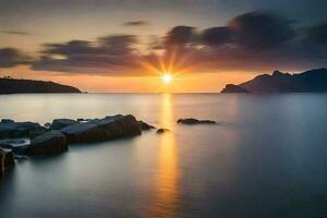 puesta de sol terminado el mar, rocas, montañas, agua, hd fondo de pantalla. generado por ai foto