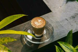 Coffee piccolo latte on wooden desk photo