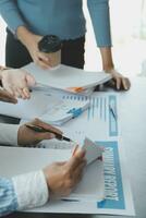 Financial analysts analyze business financial reports on a digital tablet planning investment project during a discussion at a meeting of corporate showing the results of their successful teamwork. photo