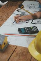 Team of multiethnic architects working on construction plans in meeting room. Engineers discussing on project in office. Mature businessman and woman standing around table working on blueprint. photo