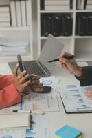 Close up Business woman using calculator and laptop for do math finance on wooden desk, tax, accounting, statistics and analytical research concept photo