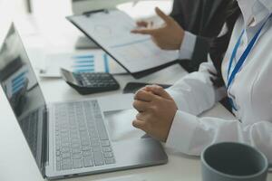 Close up Business woman using calculator and laptop for do math finance on wooden desk, tax, accounting, statistics and analytical research concept photo