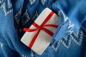 azul suéter participación blanco minimalista Navidad regalo con rojo cinta. nadie plano poner. foto
