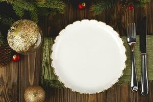 Empty white plate mock up at served Christmas table among decorations. Top view layout. photo