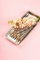 Dentist tools on metal tray with flowers on pink background. Dental care art concept. photo