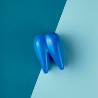 Large blue tooth lies on combined blue background. photo