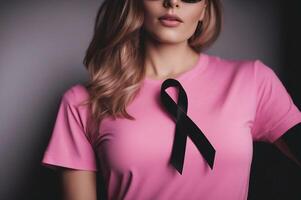 October breast cancer awareness month, woman in pink t- shirt with black ribbon. photo