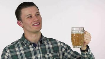 Happy young man looking away dreamily, holding mug of delicious beer video