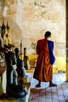 a monk is standing in front of statues photo