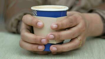 women holding  take away kraft coffee cup on table , video