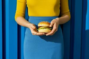 Concept woman burger lettuce hamburger yellow blue meal hand art american fast background delicious photo