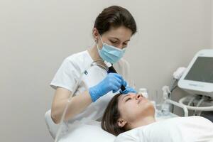 Woman receiving hydrafacial treatment in beauty salon photo