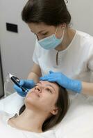 Woman receiving hydrafacial treatment in beauty salon photo