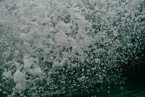 a close up of a wave crashing into the ocean photo