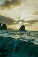 waves crashing on the shore at sunset photo