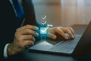 Businessman using digital pen to tick correct sign mark in virtual checkbox screen for quality document control checklist and business approve project. Businessman Take an assessment, questionnaire. photo