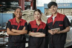 retrato de multirracial profesional mecánico equipo brazos cruzado y Mira a cámara, trabajo a coche Servicio cochera, contento mantenimiento trabajos, cheque y reparar ocupación en automotor industria negocio. foto