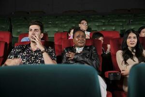 Various people in theater. Multiracial audiences, Black woman, and friends watching dramatic cinema and sad emotional expressions together on movie shows ending, entertainment lifestyle with film. photo
