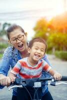 portrait of asian children riding bicycle with mother smiling face happiness emotion photo