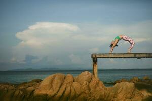 salud mujer relajante y jugando yoga actitud en playa muelle foto