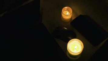 Igniting candles top view on black background. Candles burn and than light out on high framerate. Green and white natural wax candles close up. Sadness symbol video