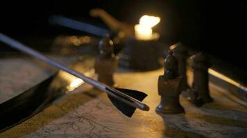 Arrow and sword on candlelit war map. video