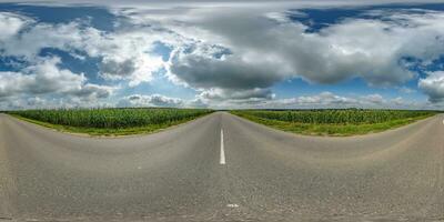 spherical 360 hdri panorama on old asphalt road among corn fields with clouds and sun on blue sky in equirectangular seamless projection, as skydome replacement in drone panoramas, game development photo