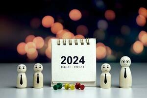 2024 calendar page with wooden dolls. concepts of Planning joint New Year resolutions and defining methods for new goals success. photo