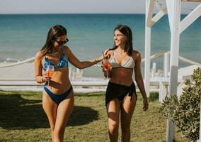 Smiling young women in bikini enjoying vacation on the beach photo