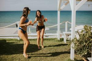 Smiling young women in bikini enjoying vacation on the beach photo