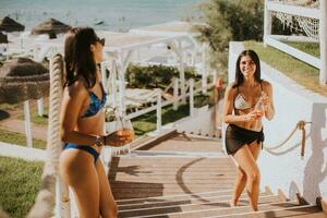 Smiling young women in bikini enjoying vacation on the beach photo