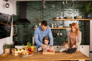 Young family preparing vegetables in the kitchen photo