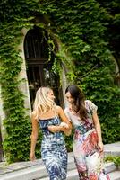 Pretty young women walking by the old house with ivy photo