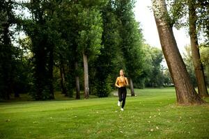 Pretty young woman running in the park photo