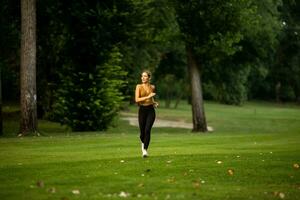 Pretty young woman running in the park photo