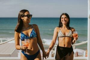 Smiling young women in bikini enjoying vacation on the beach photo