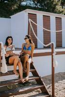 Smiling young women in bikini enjoying vacation on the beach photo