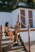 Smiling young women in bikini enjoying vacation on the beach photo