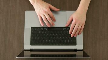 Male hands are typing on a laptop keyboard, a man works, develops a business, studies, plays a computer game. Top view. video